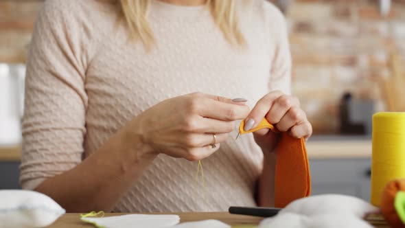 Detail video of unrecognizable woman sewing. Shot with RED helium camera in 8K.