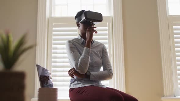 African american woman making hand gestures while using vr headset at home