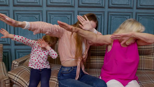 Young Woman Doing Dab Gesture Internet Meme with Senior Old Grandmother and Small Kid Child Girl