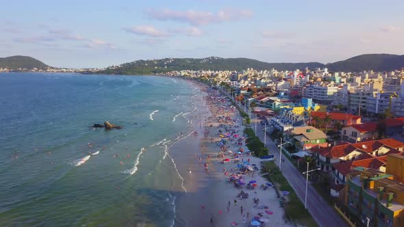 Aerial establishing shot of Bombas beach crowded with tourists enjoying at golden hour