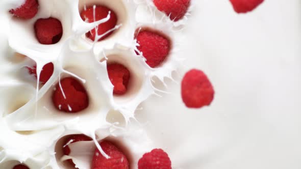 Camera follows tossing raspberries in yoghurt. Overhead shot. Slow Motion.