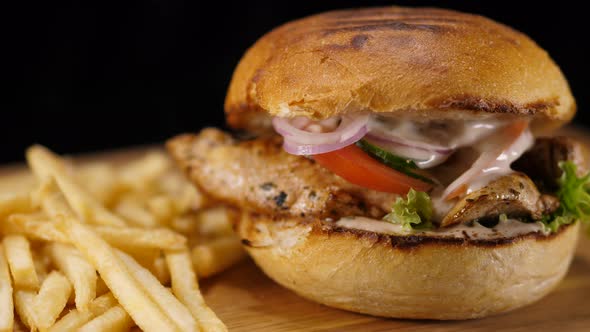 Close Up of a Grilled Chicken Burger with Bacon and French Fries