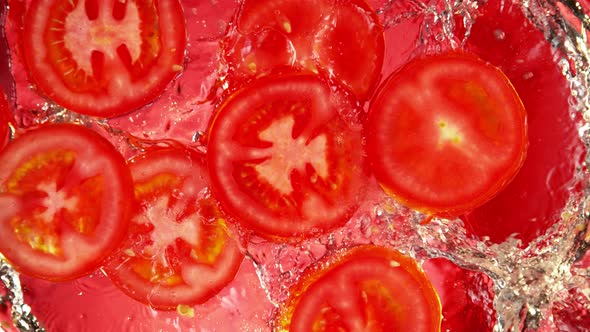 Super Slow Motion Shot of Fresh Tomato Slices Splashing Into Water at 1000 Fps