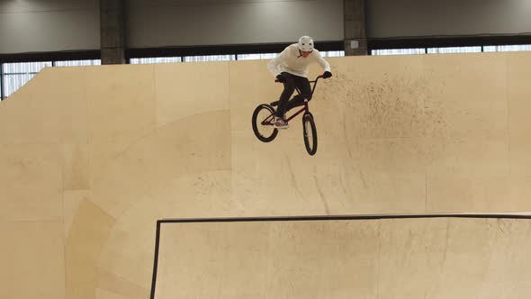 Young Man Riding on the Plywood Ramps on His Sports Bike and Performing Tricks in the Air