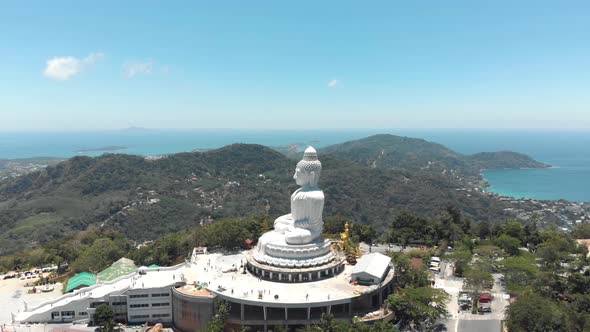 Profile view of Phuket Big Buddha overtaking the exotic urban Thai Landscape