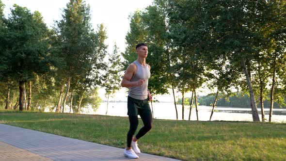 Outdoor Workout of Sporty Man Running in Park Sport Routine