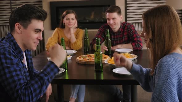 Friends Relax in the Bar with Beer,pizza and Play the Game Rock, Paper, Scissors