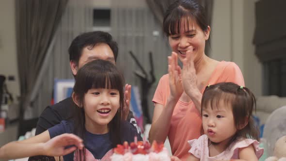 Asian happy young family have birthday party for young little child together at home. Lovely moment.