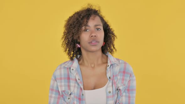 Young African Woman Feeling Scared Frightened on Yellow Background