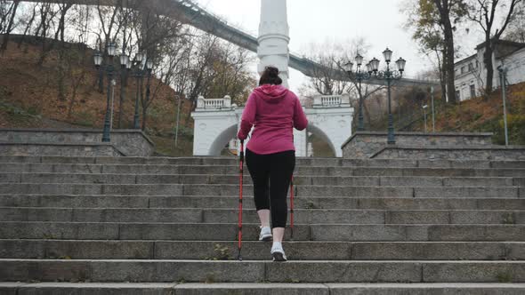 Nordic Walking. Young adult doing nordic walking exercises in city going up the stairs