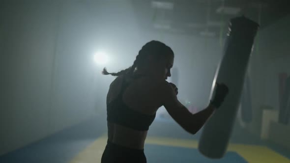 Female Fighter Trains His Punches and Defense in the Boxing Gym Contour Lighting Young Female