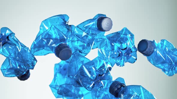 Super Slow Motion Shot of Flying Empty Plastic Bottles on Light Gradient Background