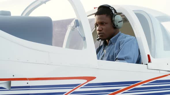 Black Aircraft Mechanic Sitting in Cockpit