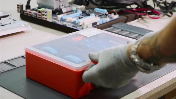 Technician Opens Box with Instruments and Tools in Computer Repair Workshop