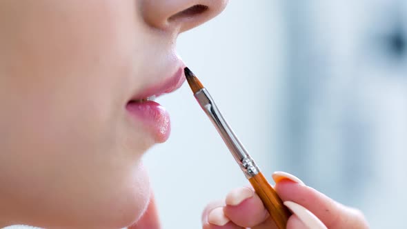 Extreme Close Up Hand Makeup Artist Making Makeup of Lips Using Brush