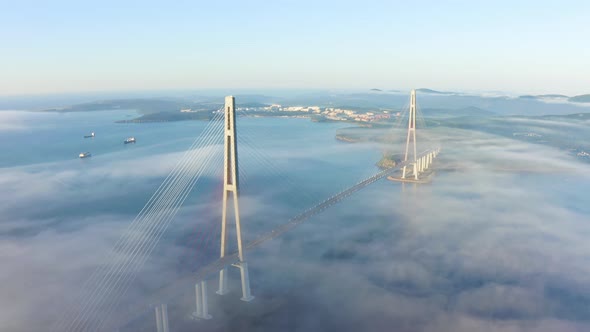 The Pylons of the Giant Cablestayed Bridge Rise Above the Seaside Morning Fog