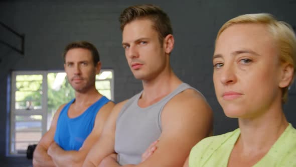 Serious fit people posing together in gym