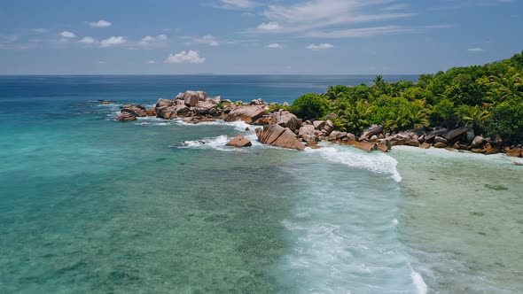 Aerial Drone View of Remote Secluded Beach with Granite Boulders Ocean Waves and Palm Trees