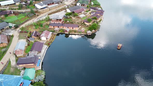 Aerial view by drone of a small boat sailing in a beautiful lake