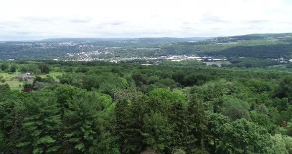 A backward dolly of the city of Ithaca New York showing the valley, colleges, and lush greenery.