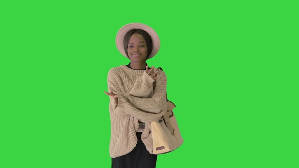 Stylish African American Woman in Knitwear and White Hat Dancing While Walking on a Green Screen