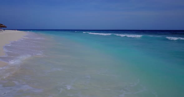 Daytime drone clean view of a white sandy paradise beach and aqua blue ocean background