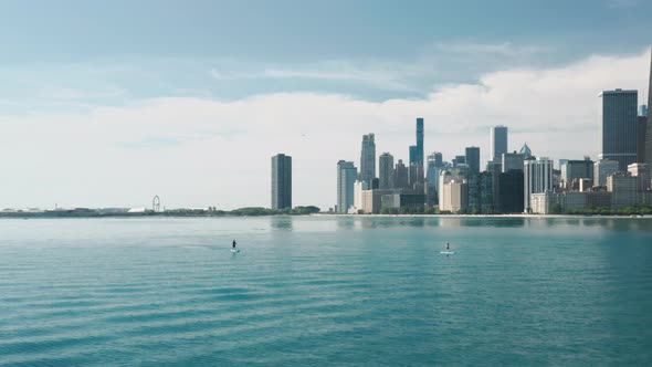 Man Swimming on Paddle Board By Michigan Lake with Chicago Cityscape Background