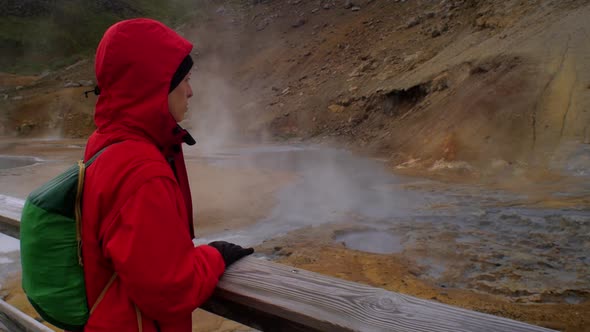 dramatic iceland landscape scenery, geothermal hot spring steam smoke rising from the ground, female