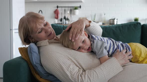 Mother Strokes Hugs Her Kid Baby Lying On Couch