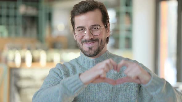 Portrait Young Man Making Heart Shape By Hand