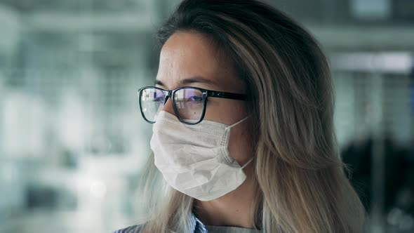 Front View of a Woman Fixing a Medical Mask on Her