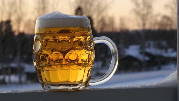 On a crisp winter afternoon in Sweden foam on a newly poured lager beer is slowly shrinking. The gla