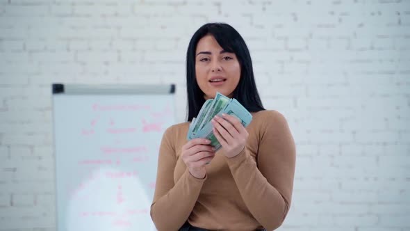 Happy woman with money. Portrait of cheerful young woman holding money banknotes