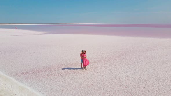 Aerial Footage of Affectionate Couple Gently Embracing on White Salty Coast of Pink Lake Looks Like