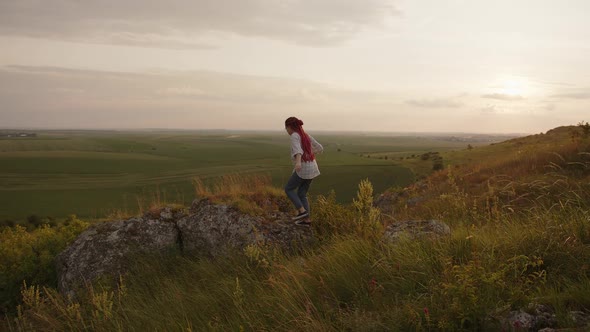 Girl Climbs on a Large Rock and Starts Take Photos