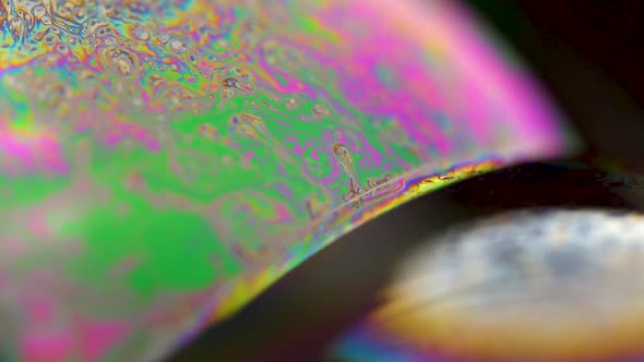 Macro shot of a soap bubble creates a colorful and psychedelic background. Rainbow colors. 