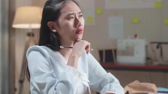 Close Up Of Asian Woman Designer Thinking While Drawing On The Layout Bond At The Office