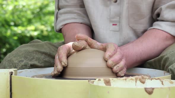 a Male Potter of Caucasian Ethnicity in a Work Shirt Makes a Bowl of Clay