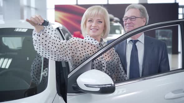 Excited Senior Caucasian Family Bragging Car Keys and Smiling at Camera