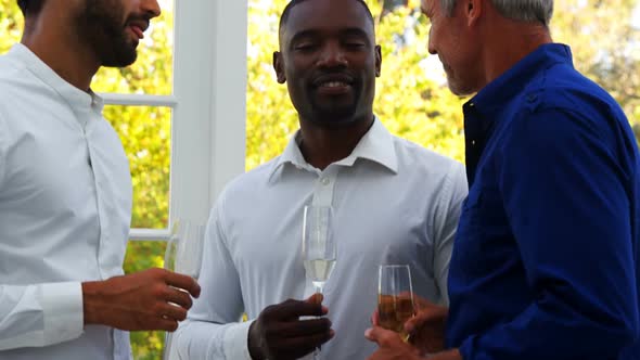 Friends interacting with each other while having champagne