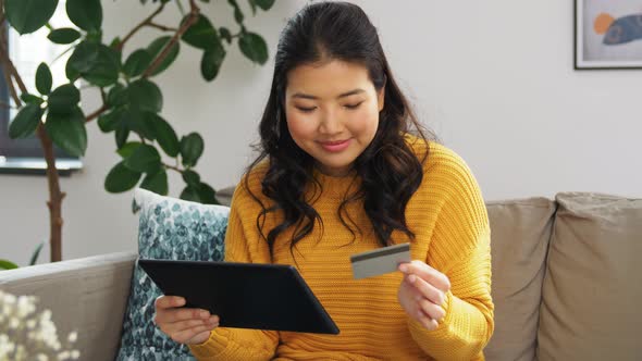 Asian Woman with Tablet Pc and Credit Card at Home