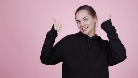 Cute Positive Young Dancing Woman Showing Thumbs Up Posing on Pink Background 