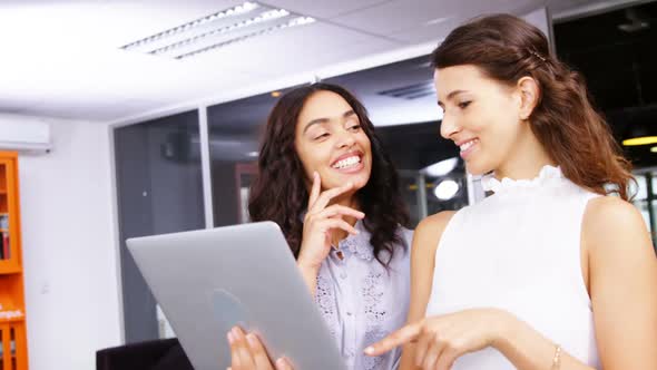 Female executives having discussion over laptop