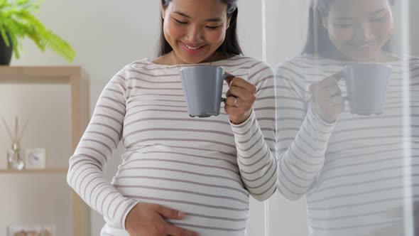 Happy Pregnant Woman Drinking Tea at Home