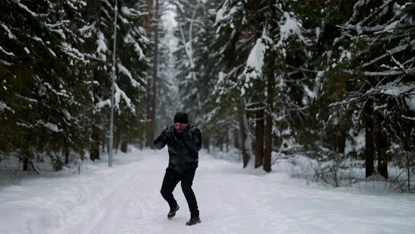 Active Military Man is Doing Exercise Alone in Winter Forest Athletic Training in Open Air