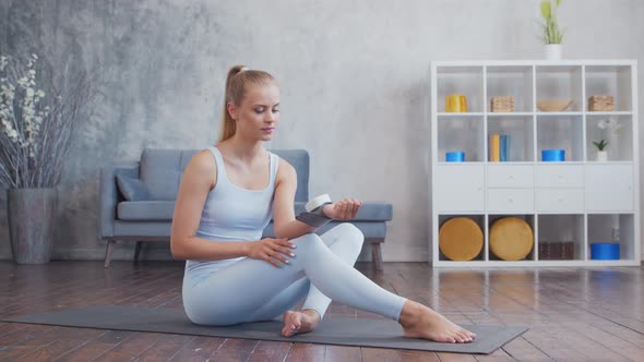 Young and sporty girl in sportswear is doing exercises at home.