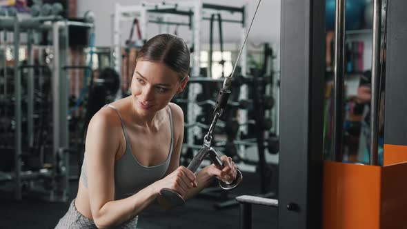 Medium Shot of a Pretty Concentrated Attractive Woman in Her 20s Holding Onto a Machine for Pumping