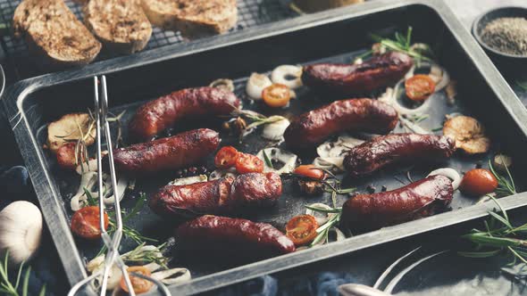 Tasty Grilled Homemade Rosemary Sausages Placed on Iron Frying Tray Over Rustic Dark Stone Table