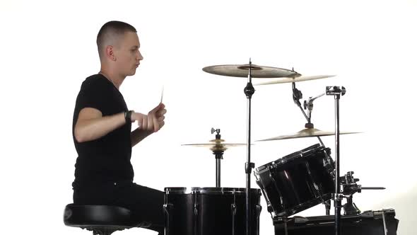Young Man Professionally Plays Percussion Instruments, White Background