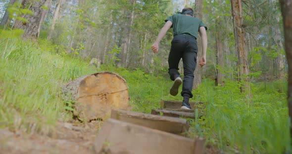 The traveler is climbing on the steps in the wild forest The wild Krasnoyarsk Stolby